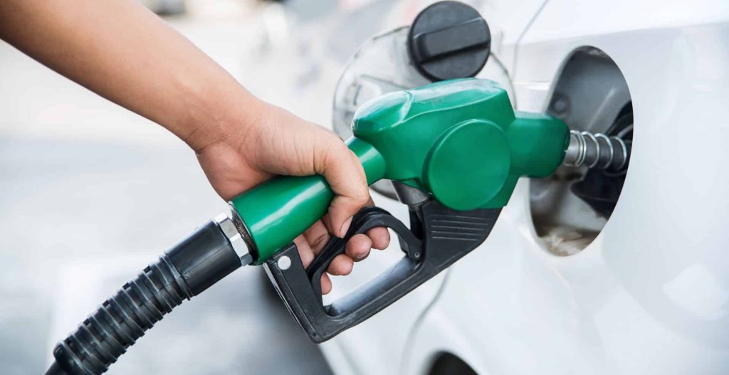 Person filling car fuel tank up at petrol station