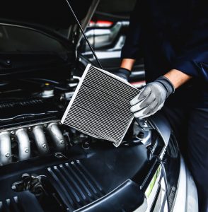 Mechanic installing AC Filter
